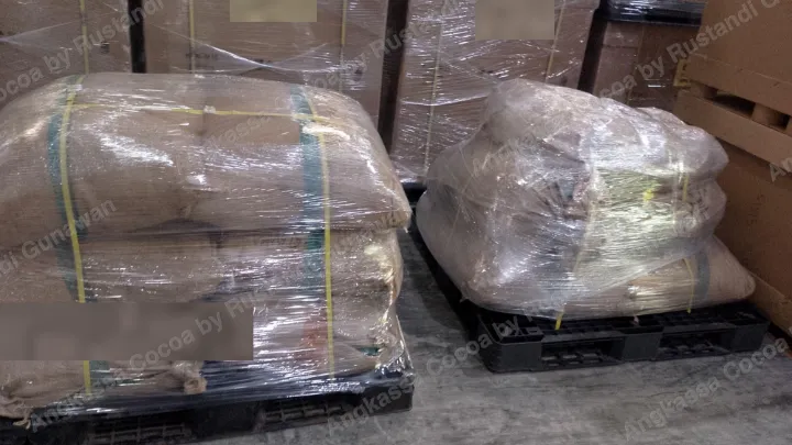 Dua palet berisi karung goni yang dibungkus plastik di gudang.